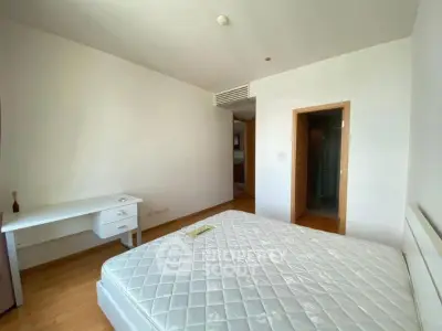 Spacious bedroom with natural light and modern furnishings in a stylish apartment.