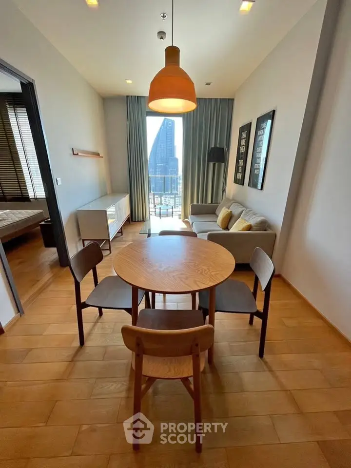 Modern living room with wooden dining set and city view from balcony, featuring stylish decor and natural light.