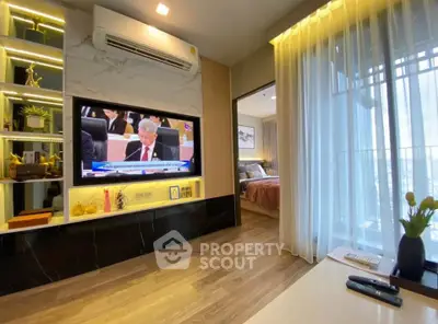 Modern living room with TV, air conditioning, and view into cozy bedroom, featuring elegant decor and natural light.