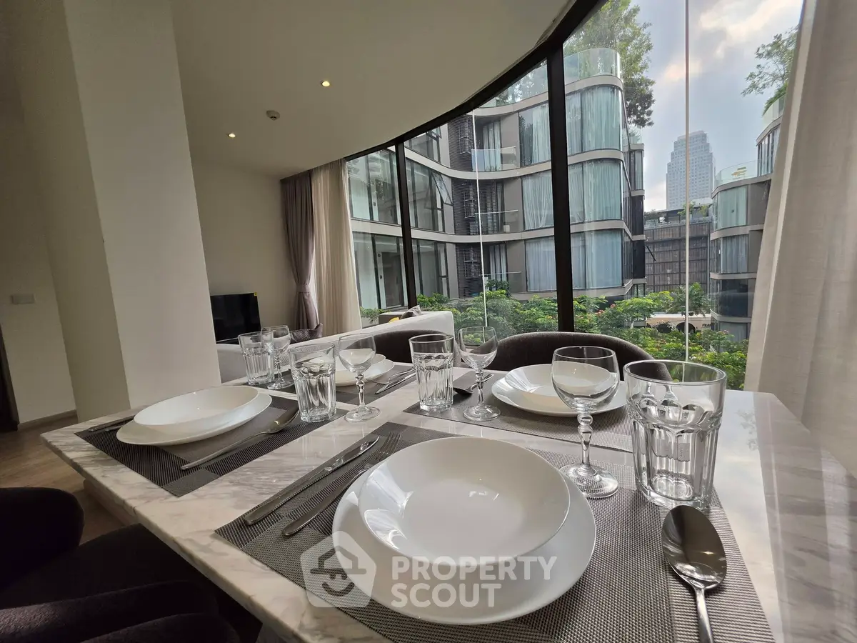 Luxurious dining area with elegant table setting and stunning city view through large windows.