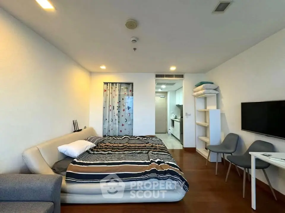 Spacious bedroom with modern decor and cozy ambiance in a stylish apartment.