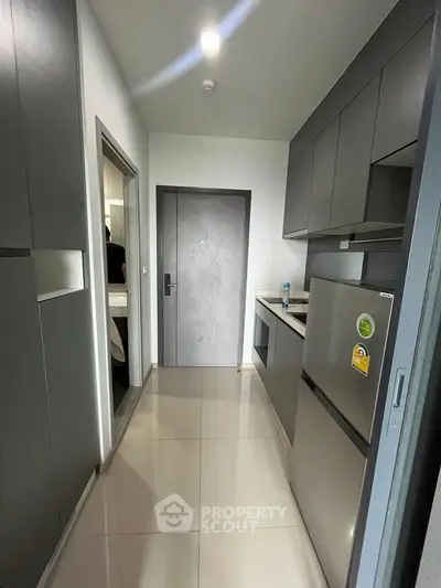Modern compact kitchen with sleek grey cabinets and stainless steel appliances