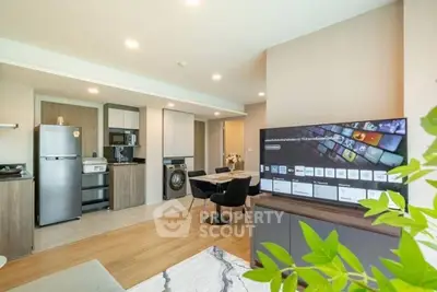 Modern open-plan living room with kitchen, dining area, and smart TV