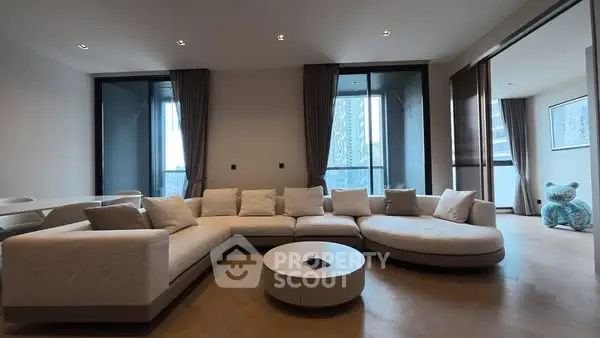 Spacious modern living room with large sectional sofa and floor-to-ceiling windows