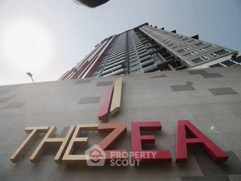 Modern high-rise building with sleek design and prominent signage, ideal for urban living.