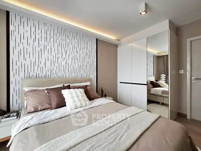 Modern bedroom with stylish decor and mirrored wardrobe in a cozy apartment.