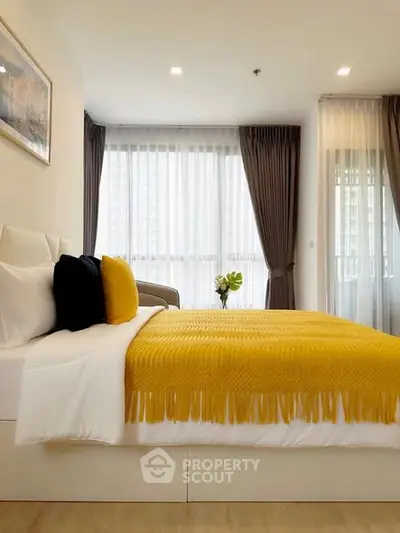 Modern bedroom with stylish decor and large windows for natural light.