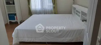 Spacious bedroom with large bed and natural light from window, ideal for comfort and relaxation.