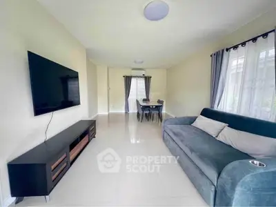 Spacious living room with modern sofa and large TV, perfect for relaxation.