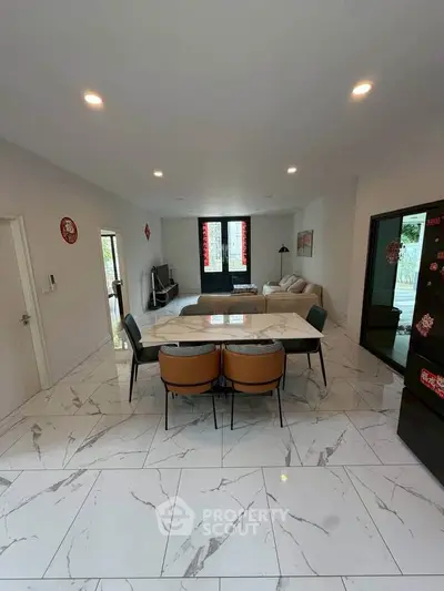 Spacious modern living room with marble flooring and elegant dining area.