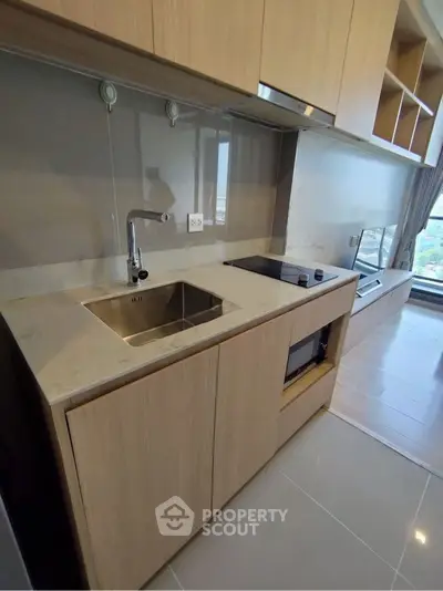 Modern compact kitchen with sleek cabinetry and integrated appliances