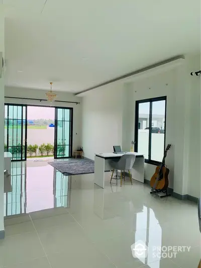 Spacious and bright living room with gleaming floor tiles, large windows, and a serene balcony view, perfect for modern living and entertaining guests.