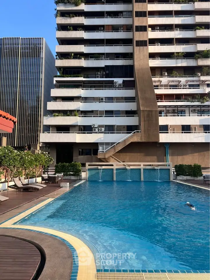 Luxurious apartment building with a stunning outdoor pool and modern architecture.