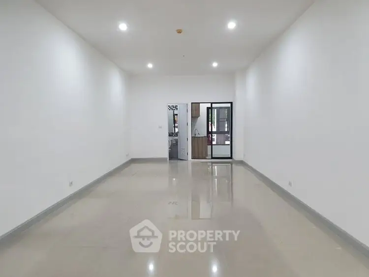 Spacious empty room with glossy tiled floor and bright lighting, ideal for customization.