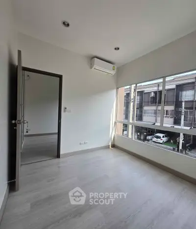 Bright and airy bedroom with large windows and modern air conditioning unit.