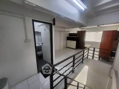 Spacious interior with modern design and natural lighting, featuring a sleek railing and tiled flooring.