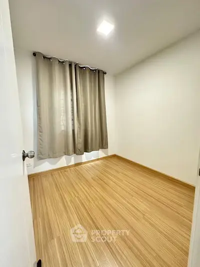 Spacious empty bedroom with wooden flooring and natural light