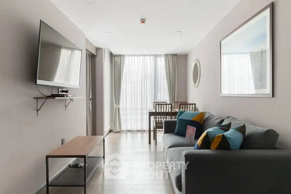 Modern living room with sleek furniture and large TV, perfect for relaxation and entertainment.