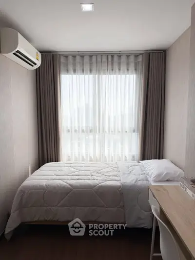 Cozy bedroom with natural light, featuring a comfortable bed and modern decor, perfect for relaxation.