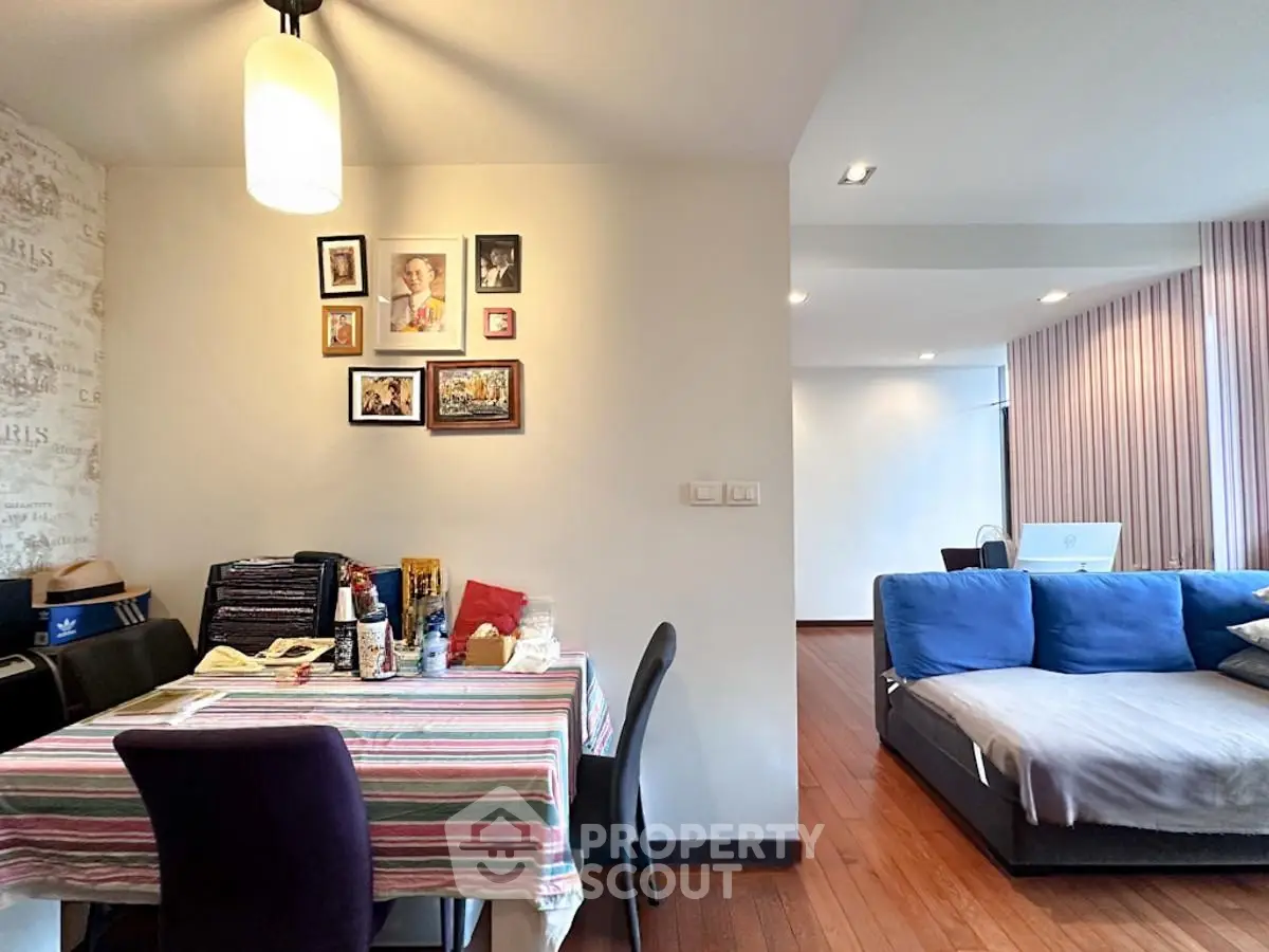 Spacious living and dining area with stylish decor and cozy seating in modern apartment.