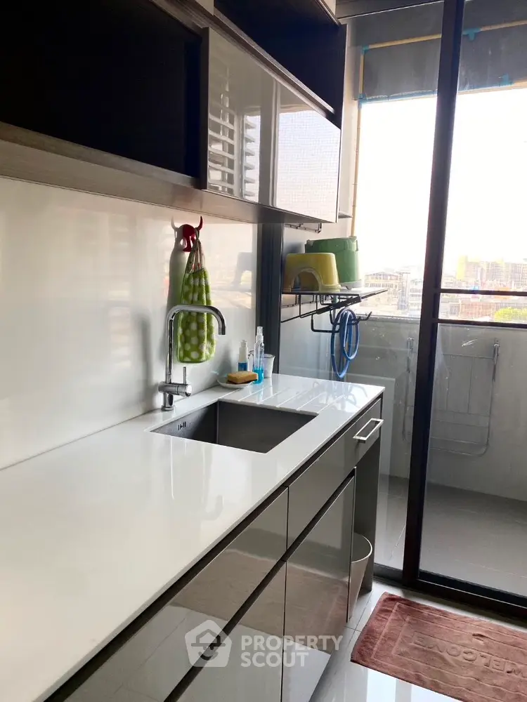 Modern kitchen with sleek countertops and balcony view, perfect for urban living.
