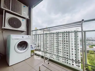 High-rise apartment balcony with washing machine and city view, perfect for urban living.