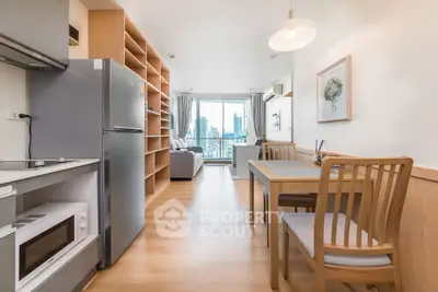Modern open-plan living room with dining area and city view, featuring sleek furniture and natural light.