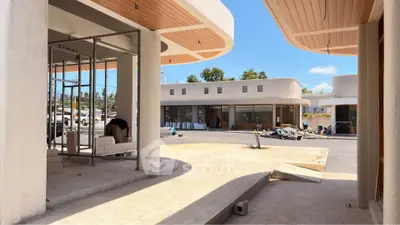 Modern commercial building under construction with sleek design and open spaces.