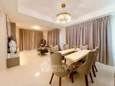 Luxurious open-plan living and dining area with elegant chandelier and plush seating