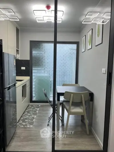 Modern kitchen with sleek design, featuring a compact dining area and stylish lighting, perfect for urban living.