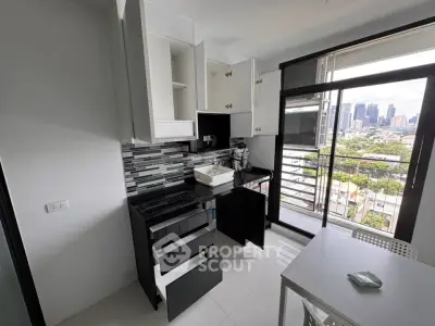 Modern kitchen with sleek black and white design, city view from balcony, and open layout.