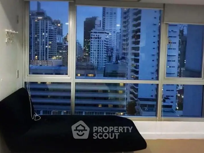 Stunning cityscape view from modern apartment with large windows and sleek interior design.
