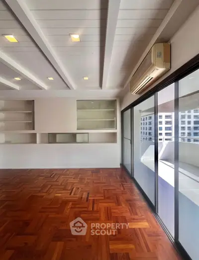 Spacious living room with wooden flooring and large windows in modern apartment