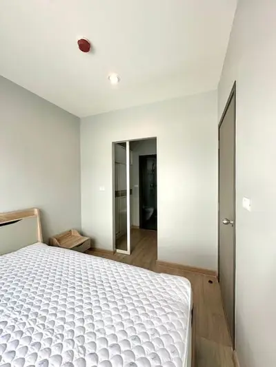 Modern bedroom with minimalist design and ensuite bathroom in a contemporary apartment.