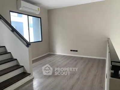 Modern empty room with wooden flooring and staircase, ideal for customization.