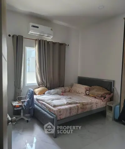 Cozy bedroom with modern air conditioning and stylish decor, perfect for relaxation and comfort.