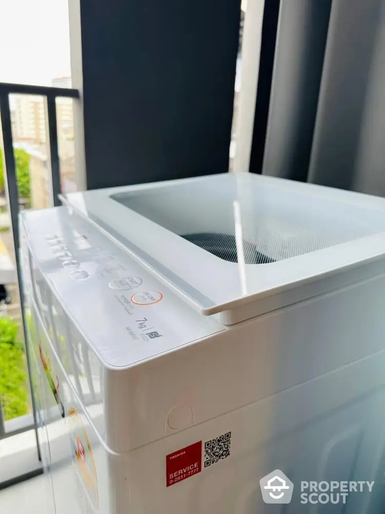 Modern washing machine on a balcony with city view