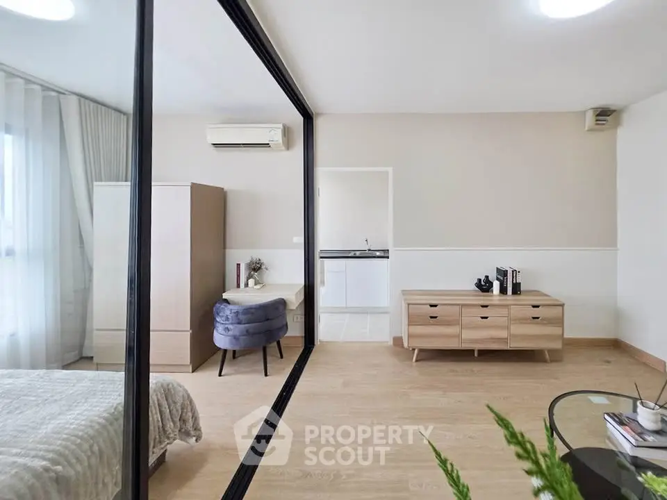 Modern bedroom with stylish decor and large mirror reflecting natural light