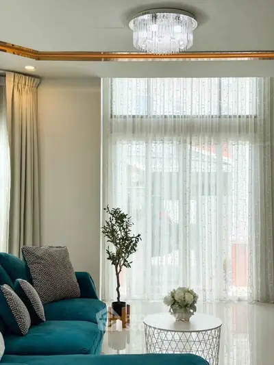 Elegant living room with teal sofa and modern chandelier