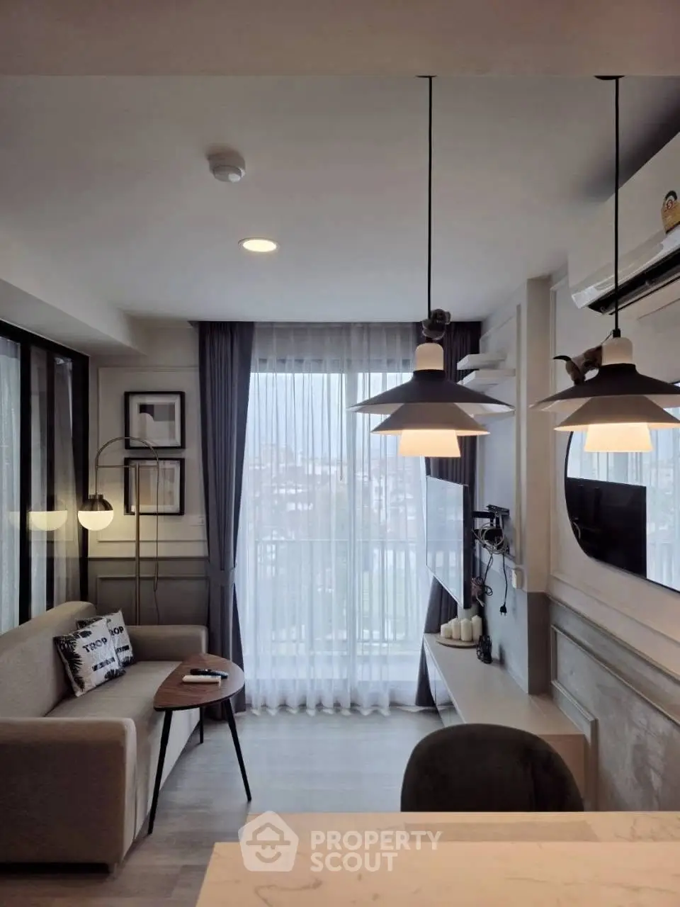 Modern living room with stylish lighting and cozy seating area, perfect for relaxation and entertainment.