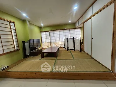 Spacious Japanese-style living room with tatami flooring and shoji screens, perfect for serene living.