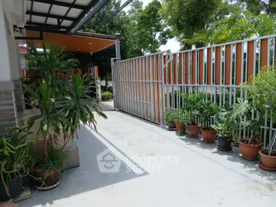 Spacious outdoor area with potted plants and modern gate design.
