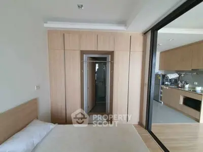 Modern bedroom with wooden accents and open kitchen layout