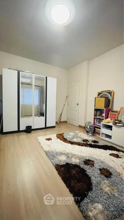 Spacious bedroom with modern wardrobe and cozy carpet, perfect for relaxation.