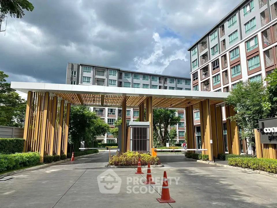 Modern condominium entrance with stylish wooden design and lush greenery