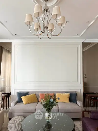 Elegant living room with chandelier, cozy sofa, and stylish decor