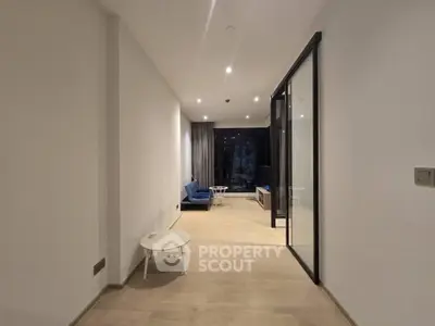 Modern living room with sleek design and glass partition, featuring cozy seating and ambient lighting.