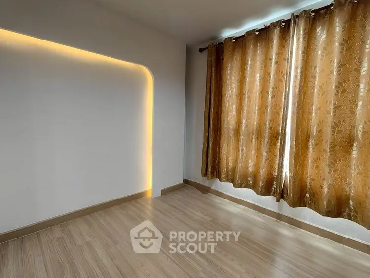 Spacious room with elegant lighting and wooden flooring