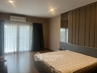 Spacious bedroom with modern design and large window for natural light