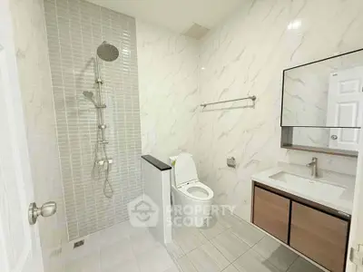 Modern bathroom with sleek shower and elegant vanity in a contemporary home.